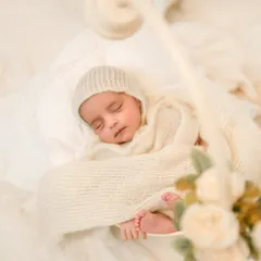 A detailed close-up capturing the baby's tiny toes peeking out from a warm, knitted wrap. These simple, focused shots are about preserving the memory of just how small and perfect they are.
