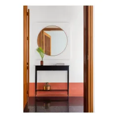 Our Ved House project was featured on the cover of Livingetc India. This shot of the entryway shows the minimalist black console, circular mirror, and the striking contrast between the black granite floor and terracotta-hued skirting.