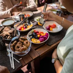 Participants enjoying a colorful and nutritious meal at our wellness retreat. The menu includes a variety of fresh fruits, salads, and even healthy, oil-free cookies, showing the abundance of a plant-based lifestyle.