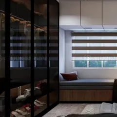 A sleek and modern walk-in closet with black-framed, smoked glass doors. A cozy, cushioned window seat is built in, providing a comfortable spot to get ready.