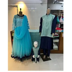 A coordinated family set in shades of blue, designed for a traditional event. The mother's anarkali gown, father's kurta, and son's matching ethnic wear all tie together with the same patterned fabric.