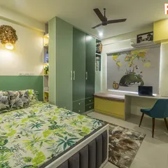 This vibrant kids' room is designed around a travel and nature theme. It features green and yellow cabinetry, a custom study area, and plenty of open and closed storage for toys and books.