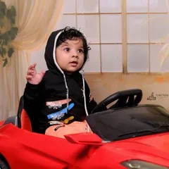 Capturing a moment of curiosity from the driver's seat. I focus on getting natural expressions as the baby explores the toy car and its steering wheel.