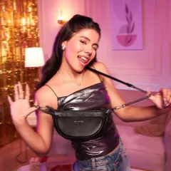 A fun and candid shot for a handbag campaign. The makeup is party-ready, with a shimmery top, glowing skin, and a playful expression, perfect for a night out.