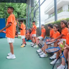 Our young players listen attentively during a group session. We foster an environment of focus and discipline, balanced with fun and encouragement, to help them absorb new skills and strategies.