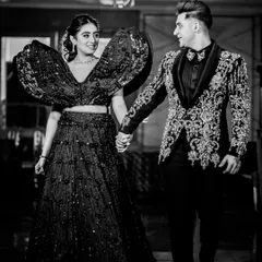A stylish black and white shot of Muskan and Dhruv making their entrance. The bride's dramatic, high fashion lehenga is the star of this shot, showcasing our eye for capturing unique bridal wear.