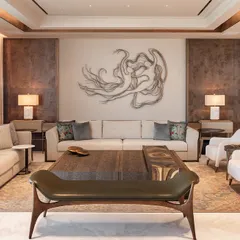 Another view of the DLF Camellias living space, showcasing the custom-designed bench and side chairs. The material palette of warm woods, soft fabrics, and metallic accents creates a layered, tactile experience.