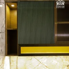 This modular kitchen unit showcases a dark green fluted veneer, paired with fluted glass and warm backlighting. It's a sophisticated and moody design for a modern kitchen.