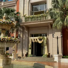 I decorated the entire front of this beautiful building for a large event. The floral work on the entrance arch, balcony, and fountain creates a cohesive and grand look.