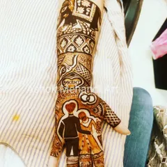 A perfect design for a ring ceremony, this mehndi features a portrait of the couple, their initials, and wedding rings, along with a majestic elephant motif on the forearm.