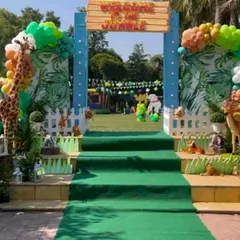 I can transform any outdoor space into a magical party venue. Here's a 'Welcome to the Jungle' entrance I created for a lawn party, complete with a custom sign, balloon arch, and life-sized animal props to excite guests from the moment they arrive.
