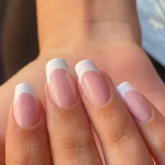 A close-up of the classic French manicure, showing the flawless smile line and glossy finish.