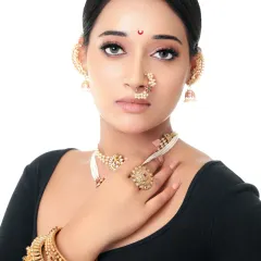 A portrait of royal elegance. This shot focuses on the model's expressive eyes and the exquisite traditional Maharashtrian jewelry, including the nath and ear cuffs.