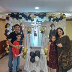 The birthday twins and their parents posing for a photo in front of the custom backdrop we created. We love capturing these happy family memories.