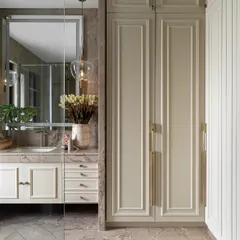 A classic and timeless bathroom design in the Juneja Residence. The warm beige tones of the cabinetry and the rich veining of the marble floor create a sophisticated and serene atmosphere.