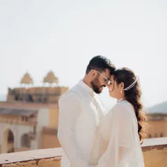 An intimate close-up with Amer Fort softly focused in the background. This shot emphasizes the couple's connection while still grounding their story in a historic, royal setting.