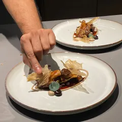 Adding the final, delicate garnish to a dish. These small details are what elevate a meal from good to great.