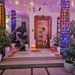The entrance to a home for a Guruji Satsang, decorated to welcome guests into a spiritual space. I used traditional marigold garlands, fairy lights wrapped around the pillars, and earthen diyas to create a warm and inviting pathway.