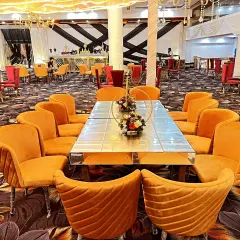 Another angle of the long table guest seating arrangement. This view shows how the seating is arranged within the larger banquet hall, which features a bold floral carpet.
