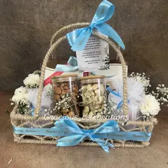 A perfect example of a premium housewarming return favor. This elegant jute basket includes jars of high-quality dry fruits, fresh baby's breath flowers, and a custom-printed ribbon with a thank you message from the family. It's a warm and welcoming gift for guests.