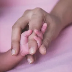 One of the most powerful images: a newborn's tiny hand wrapped around their parent's finger, symbolizing trust and connection.