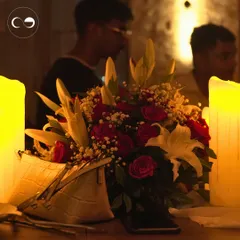 A simple yet elegant table setting for our own anniversary celebration. A bouquet of red roses and lilies, surrounded by glowing candles, creates a classic and romantic ambiance.