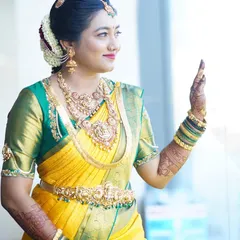 A candid moment of the bride looking out a window, her henna-decorated hands adding to her grace and elegance.