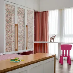 The daughter's bedroom in the 'Cover me in Sunshine' project features these charming wardrobe shutters with fabric sandwiched between glass panels, complemented by custom wooden handles.