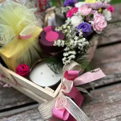 A close-up on the textures and colors of the get well soon hamper, from the soft tulle wrapping to the rich pink ribbons.