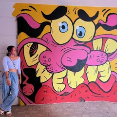 Me posing with my vibrant mural of Courage the Cowardly Dog, created for the Fam Jam Graffiti Battle. This piece is a nostalgic nod to 90s cartoons, reimagined in my bold street art style.
