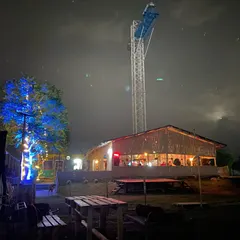 The night vibe at our club, showing our on-site cafe building and the iconic bungee tower illuminated against the night sky, highlighting the unique features of our venue.