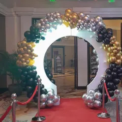 A grand circular entrance arch decorated with black, gold, and silver balloons for an 18th birthday party.