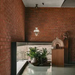 A glimpse from an upper level shows how greenery is integrated into every part of the architecture. Potted ferns are placed to be seen from multiple vantage points, making the connection to the outdoors feel constant and layered.