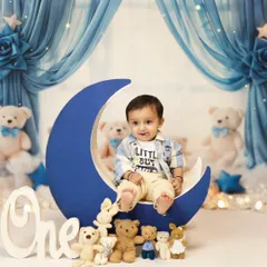 Before the cake smash begins, we capture some sweet portraits. Here, the birthday boy is sitting on a big blue moon prop, surrounded by teddy bears, with a little tongue-out smile. This setup is part of our popular "twinkle twinkle little star" theme.