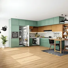This spacious L-shaped modular kitchen is designed for both beauty and efficiency. It combines a refreshing sage green finish with warm wood tones, a patterned backsplash, and a fully integrated pantry unit for maximum storage.