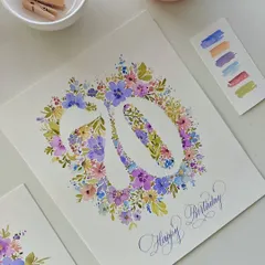 The finished 70th birthday card, featuring a beautiful floral monogram of the number '70' surrounded by watercolor flowers, with "Happy Birthday" penned in elegant calligraphy.