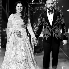 A grand entrance by the couple at their reception, captured in timeless black and white as they walk hand-in-hand amidst theatrical smoke.