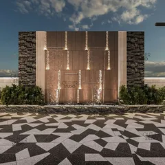 A detailed shot of the water wall, which features cascading streams of water illuminated by integrated lights. The combination of rough stone and smooth metal creates a beautiful textural contrast.