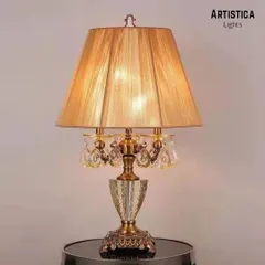For a touch of classic glamour, this table lamp combines a golden pleated shade with a crystal-accented base. Its timeless design integrates easily into any environment while leaving a lasting impression of style.