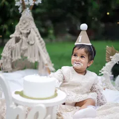 A first birthday is a memory to treasure forever. This little girl is enjoying her cake during a boho-themed picnic shoot in our garden. We provide everything, from the beautiful lace dress to the props, to make it perfect.