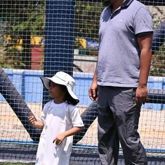 A father stands with his child at the sports meet, showing our strong parent participation.