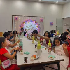 A group of happy kids at a birthday party, proudly showing off the festive bottles they decorated. It’s a wonderful way for them to express their creativity.