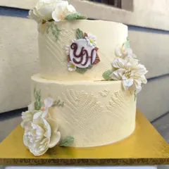 A true white beauty for an engagement. I used a textured buttercream technique to create a subtle lace pattern, complemented by a custom monogram and delicate sugar flowers for a touch of elegance.