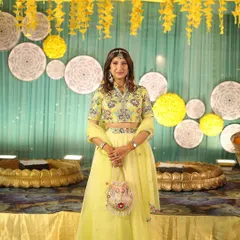 A full view of a beautiful and elegant Haldi look. The makeup is kept fresh and minimal to complement her embroidered yellow lehenga and the daytime setting.