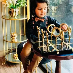 A playful shot from the kids' fashion shoot, showing the little model in his stylish outfit, complete with a brown bow tie.