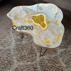 Another angle of the student-made coffee table, showing the irregular, organic shape and the beautiful gold leaf accents that catch the light.