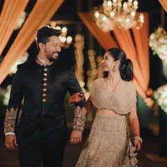 A stylish couple making their entrance at a reception with warm, elegant lighting and decor.