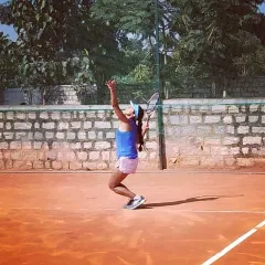 A female player demonstrates excellent serving form during the Tennis360 Open Tournament.