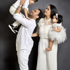 A playful family portrait that shows so much personality. The father lifting his son, the mother holding their daughter, everyone's expression is full of happiness.