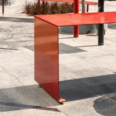 The end of the "Red Ribbon" shows how the continuous steel plate elegantly folds down to meet the ground. This detail highlights the simplicity and sculptural quality of the design, which turns a functional object into a piece of art.